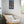 Load image into Gallery viewer, Colours of Home by Adam Young framed beside a rattan armchair
