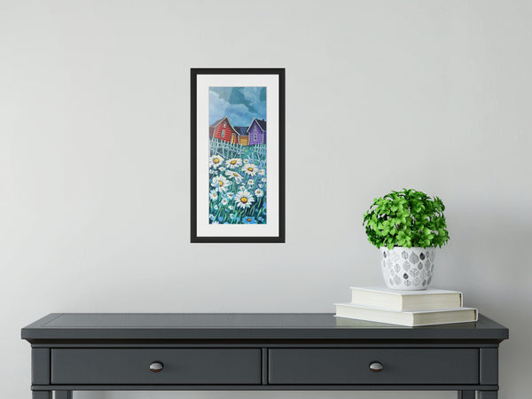 Daisies by Adam Young, matted in a black frame above a dark console table with a potted plant and books