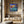 Load image into Gallery viewer, Forget Me Nots by Adam Young on a wood-panelled wall above a stone bench
